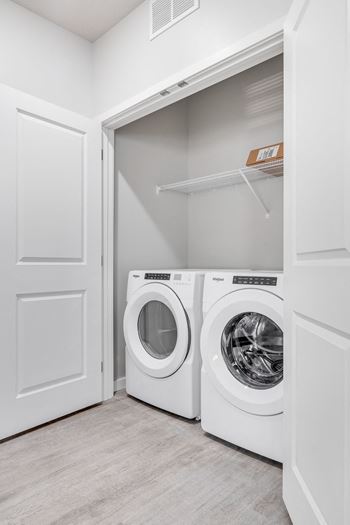 A white laundry room with two washing machines.